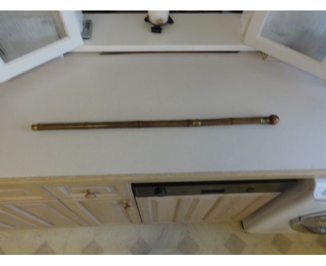 A bamboo walking stick/cane with a spherical hardwood handle 1 ½”/ 38 mm diameter. This is set on a brass collar 1 ¼” / 36 mm