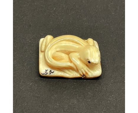 A carved fossilised Mammoth tusk signed Netsuke of a Lizard, 2.5 x 1.8cm.