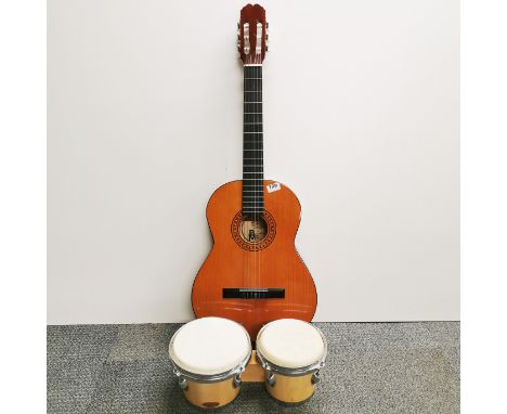 A Balmeria Spanish guitar and case with a pair of bongo drums.
