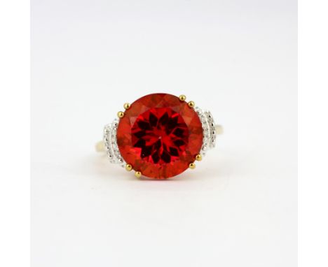 A 9ct yellow gold ring set with a large round cut red stone and diamonds, (M).