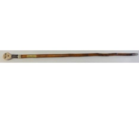 A most unusual stick. The handle is made of some composite material in the shape of a mechanical head. It has a rather ugly f
