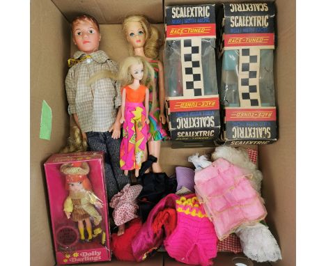 A group of Sindy and Paul dolls with accessories and two Scalextric racing cars.