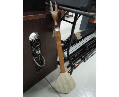 An Ethnic style single string instrument, having carved lozenge and animalistic decoration to headstock