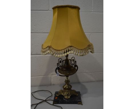 A BRASS EWER SHAPED TABLE LAMP on a slate base with a fabric shade (one loose foot)