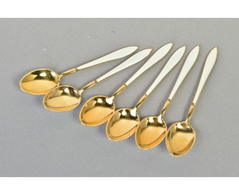 A SET OF SIX SILVER GILT AND ENAMEL TEASPOONS, the handles and back of spoons set with white shell design, stamped to the bac