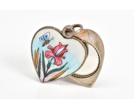 AN ENAMEL LOCKET, of white metal in the shape of a heart with enamel detail of a bee and flower to the front side, rotate sli