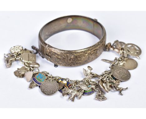 A CHARM BRACELET AND BANGLE, the charm bracelet with thirty four charms such as various animal forms, coins, shields, a stanh