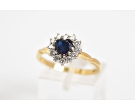 AN 18CT GOLD CLUSTER RING, set with a central heart shape sapphire with a round brilliant cut diamond surround, to the plain 