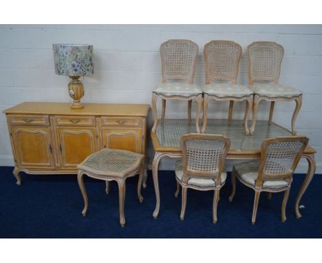 A MODERN BLEACHED WOOD FRENCH DINING SUITE, with wicker work decoration, comprising a serpentine glass topped table on cabrio