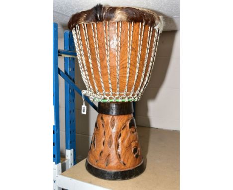 NATIVE ART INTEREST, a carved drum covered with deer skin, having handles and carved base, approximate height 64cm