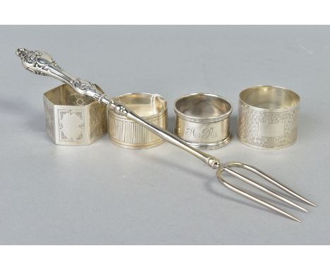 FOUR SILVER NAPKIN RINGS AND A SILVER BREAD FORK, the napkin rings of various designs to include plain, floral and engine tur