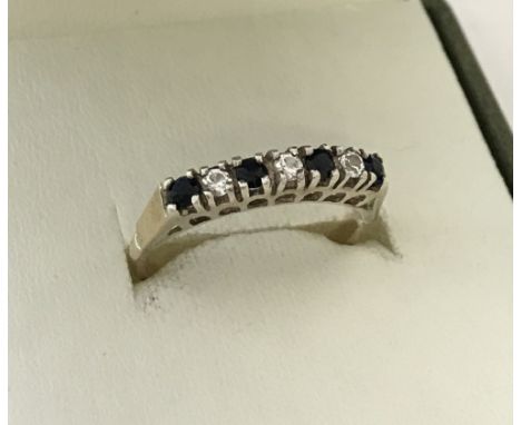 A silver and 9ct gold ladies dress ring set with alternate blue and clear stones. Ring size O½.