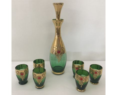 A bohemia style glass decanter and 6 matching glasses. Green glass with gold decoration.