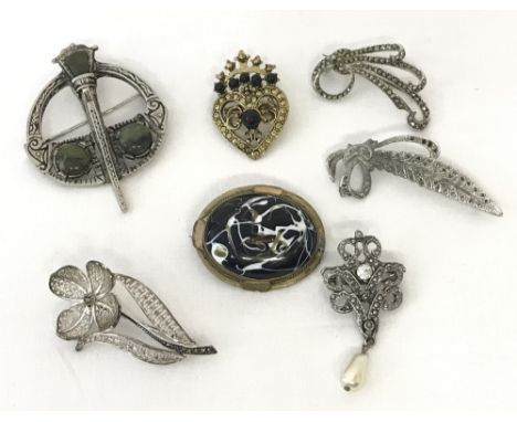 A collection of 7 silver and costume jewellery brooches. To include Celtic design, marcasite set and modern enamel.