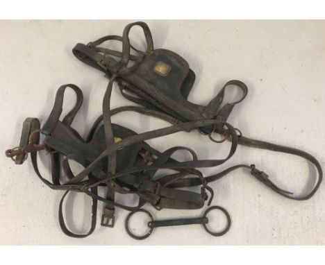 A small collection of vintage horse tack. 2 sets of blinkers with leather straps and a bit.