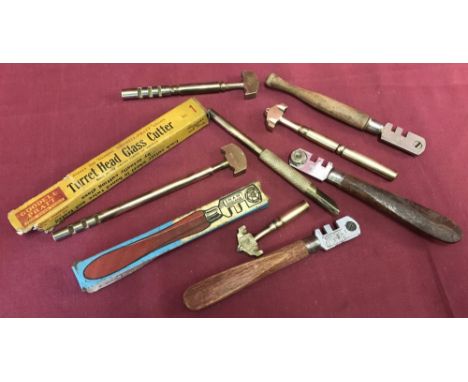 A small tray of vintage glass cutters to include early brass examples.