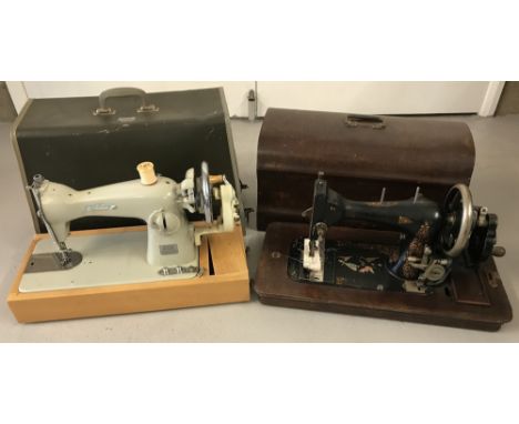2 vintage cased sewing machines. A Chapman Super Deluxe together with a wooden cased American machine with gilt decoration.