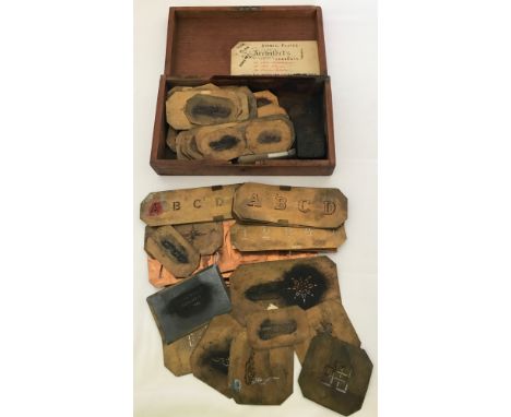 A wooden box containing a quantity of vintage brass and copper stencils. To include full sets of letters & numbers, room name