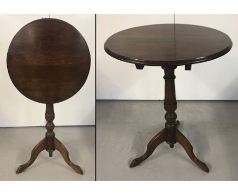 A small vintage dark wood circular shaped tip top table with tripod feet. Raised on a turned pedestal. Approx. 94cm tall x 48