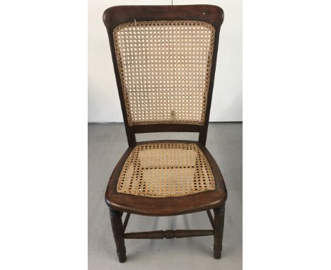 A vintage dark wood framed, cane seated and backed hall chair. With turned decoration to legs. Approx. 89cm tall.