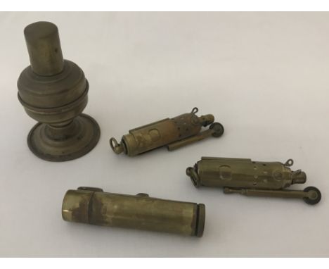 3 vintage trench art lighters together with one other brass table lighter.