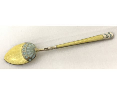 A silver and guilloche Art Deco design spoon by Henry James Hulbert. Pale yellow and blue enamel to both sides of handle and 