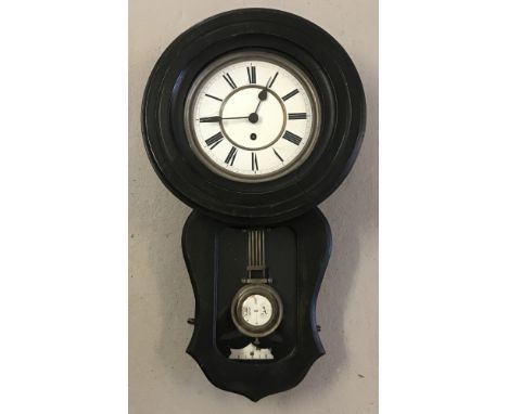 A vintage dark wood wall hanging pendulum clock with enamelled face and detail to pendulum. In need of repair, no key present