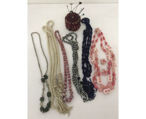 A collection of vintage and retro glass and plastic bead necklaces. Together with a handmade vintage pin cushion with a colle