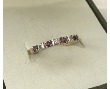 A 9ct gold ruby and diamond stone set half eternity ring. Size N.