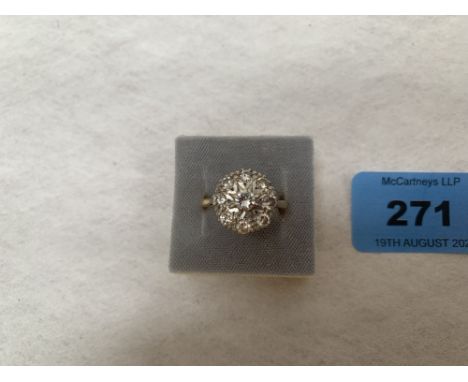 A nine stone diamond cluster ring. In gold marked 18ct. 4g gross. Size O. Diameter of setting 12mm