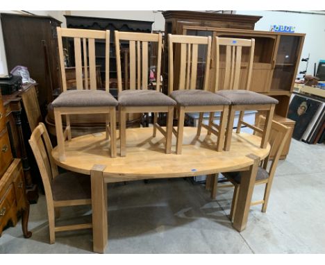 A 6'6' light oak oval dining table with a set of six chairs 