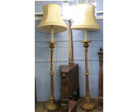 Good quality pair of carved gilt wood lamp standards in Orientalist taste with leaf carved and wrythen turned column, spreadi