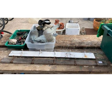 Meat hooks on wooden boards, pigeon decoys and hand tools
