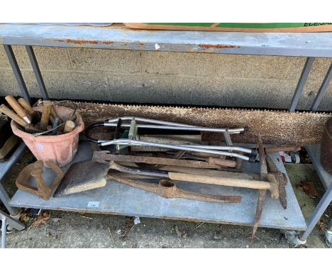 Shelf of tools to include large saw, pick axes, shovels etc