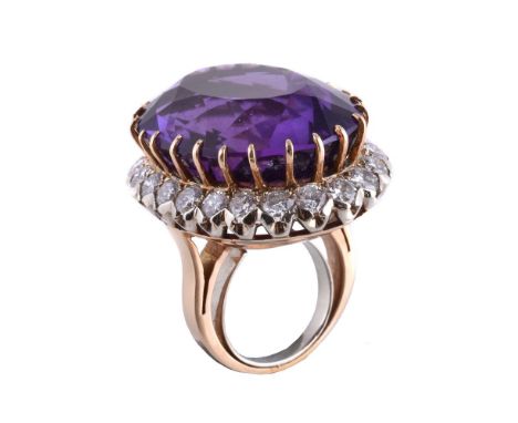 An amethyst and diamond ring, the oval cut amethyst, estimated to weigh 40.00 carats, within a a surround of brilliant cut di