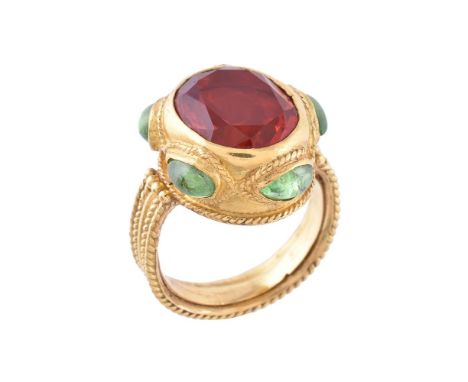 A fire opal and peridot ring by Natalia Josca, the oval cut fire opal collet set within a surround set with pear shaped caboc