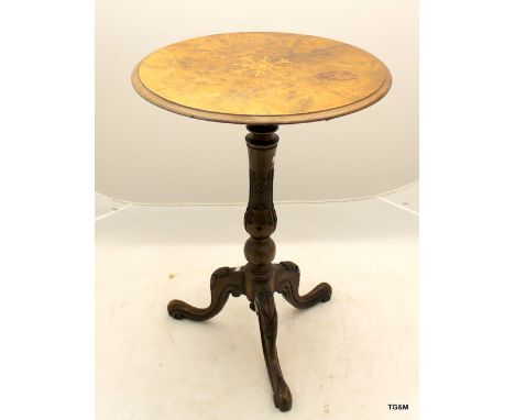 A round walnut topped lamp table on carved trifold legs 69 x 50cm