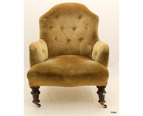 A button back nursing chair on turned front legs and castors 85cm high