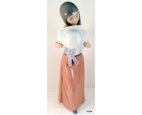 A Lladro lady holding a sun hat