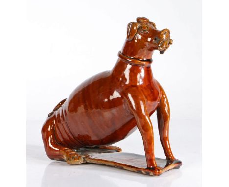 19th Century treacle glazed pottery dog flask, probably America Pennsylvania, the seated dog with a game bird clutched in the