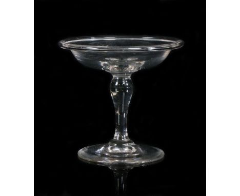 A 19th Century glass patch stand, of small proportions, the dished top with folded edge above a tapered stem and arched foot,