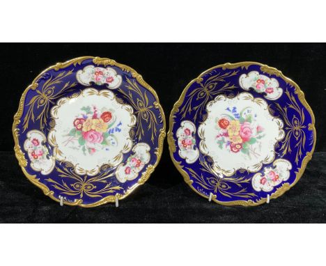 A pair of Coalport shaped circular cabinet plates, the central field flanked by three shaped cartouches, each printed with su