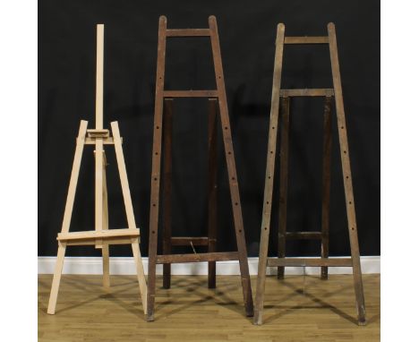A floor standing artist's easel, 183cm high; another similar; a smaller easel (3) 