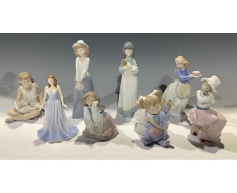 A Nao figure, ballerina; others, girl with cake and puppy, girl in a bonnet with puppy, others similar; a Royal Doulton figur