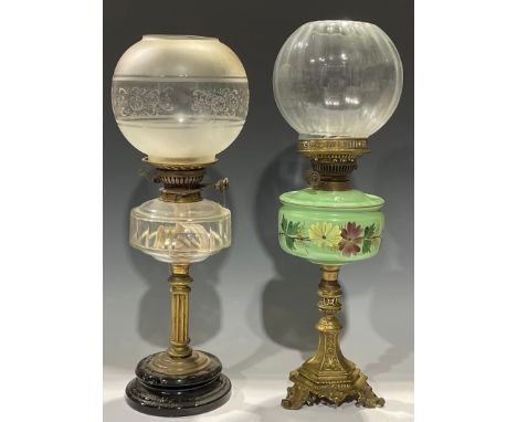 A late 19th century oil lamp, cast brass support, hexagonal base with tripod feet, green opaque glass reservoir, painted with