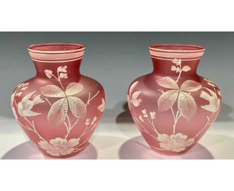 A pair of Stourbridge type pink opaque glass shoulder vases, painted in white enamel with birds perched amongst leafy blossom