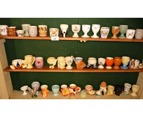 Large collection of assorted china egg cups, inc. Carlton Walking Ware (3 shelves)