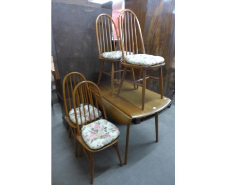 An Ercol style light oak drop-leaf table and four chairs