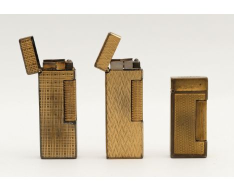 Alfred Dunhill; Two gents gold plated rollagas cigarette lighters, together with a ladies example, having engine turned decor