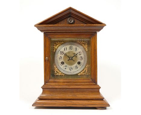 An early 20th century oak cased bracket clock, having silvered chapter ring with Arabic numerals over a gilt brass dial, the 